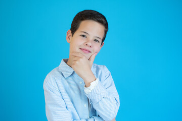 portrait of handsome boy smiling over blue background.