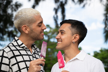 Gay couple having icecream in a public park