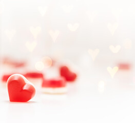 Valentines day background with red heart at foreground and defocused champagne bottle at background.