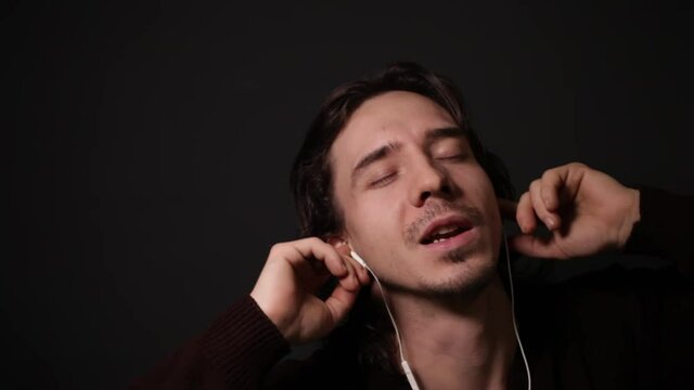 A man listens to music with headphones Man sings along, low key