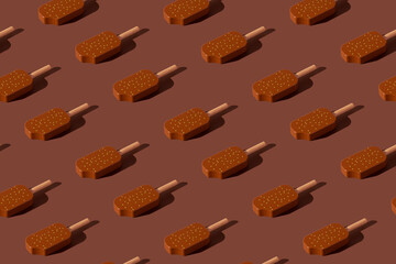 Chocolate popsicles pattern on a brown background. Minimal ice cream concept.