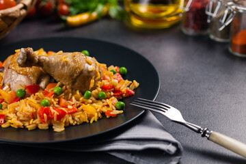 Arroz con pollo. Baked pieces of chicken with bone, rice with paprika and peas.