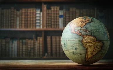 Fotobehang Old globe on bookshelf background. Selective focus. Retro style. Science, education, travel, vintage background. History and geography team. © Tryfonov
