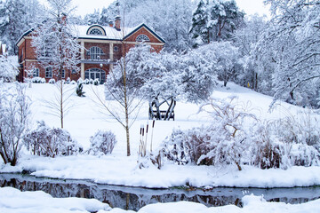 Red brick house in a winter landscape. House in the Forest by the river