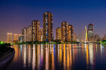 Fototapeta na wymiar Beautiful evening scene of Sumida river with famous modern Tsukishima district Tokyo, Japan, travel background
