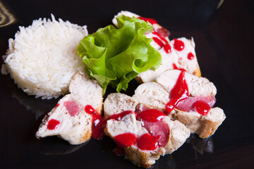 Chicken rolls with berry sauce, rice, and lettuce.