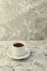 A white cup of coffee on a grey background. Hot drink concept. Coffee shop, espresso, copy space