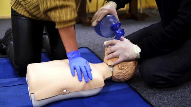 Process of cardiopulmonary resuscitation. People practicing cardiopulmonary resuscitation on mannequin at first aid class