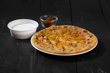 Indian breakfast dish paneer paratha serve with curd or chutney