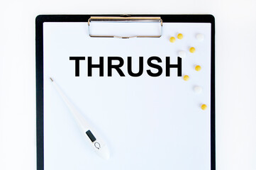 On the tablet for the letter text THRUSH, next to the thermometer and yellow tablets.