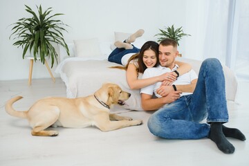 Happy couple with dog in living room