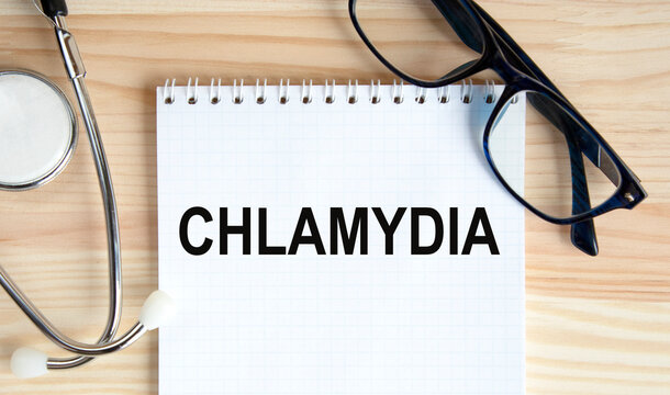 In the notebook is the text of CHLAMYDIA, next to glasses and stethoscope.