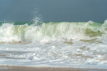 Big waves and surf on a sandy tropical beach
