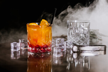 Orange aperol cocktail with ice on dark background