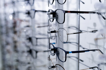 Raw of fashion elegance glasses in the store. Showcase with glasses in modern ophthalmic store. Closeup.