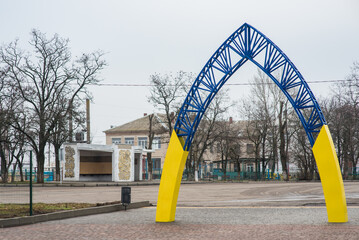 Yellow-blue, metal arch to the city park rises at the entrance