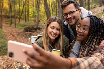 Smiling hikers taking selfie in the forest during break