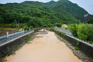 Fototapeta na wymiar Muddy river bridge and scenery on both sides