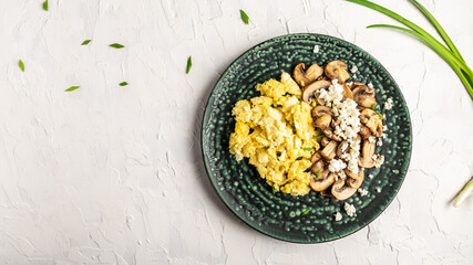 Scrambled Eggs with Mushrooms and Cottage Cheese. Delicious breakfast or snack on a light background, top view