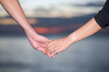 couple holding hand walking near the beach