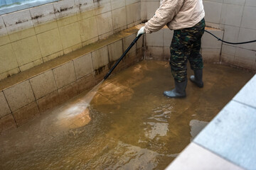 Cleaning swimming pool using high pressure power washer.