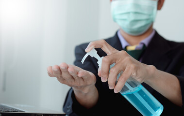 Obraz na płótnie Canvas Man hands using wash hand alcohol gel or sanitizer bottle dispenser, against Novel coronavirus or Coronavirus Disease (Covid-19) .