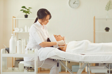Woman dermatologist making procudure of apparatus facial skincare for relaxing woman