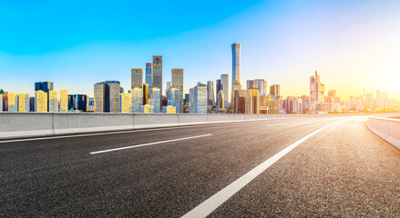 Asphalt road and modern city commercial buildings in Beijing at sunrise,China.