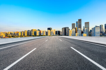 Asphalt road and modern city commercial buildings in Beijing at sunrise,China.