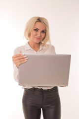 Naklejka premium Blonde stands on a white background with a laptop. Office worker stands with laptop in white studio. 