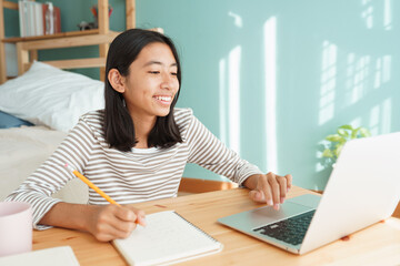 Asian girl learning online via the internet tutor on  computer at home