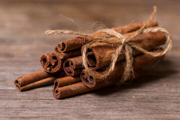 cinnamon sticks on old wooden background, selective focus
