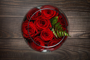 Top view of a Red roses in a aquarium with water against wooden background. Valentine holidays.