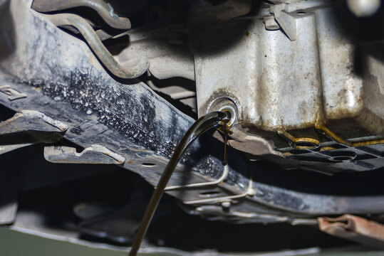 Dirty And Used Engine Oil On A Car Drains From The Engine Sump I