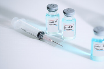 Coronavirus COVID-19 concept. blue liquid in vaccine vials and Syringe on white background and copy space for text