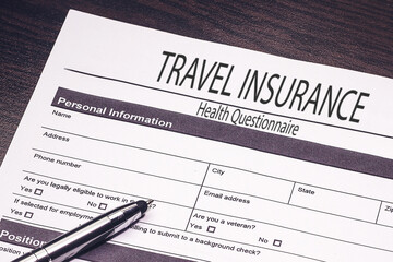  Travel insurance application form on wooden desk background 