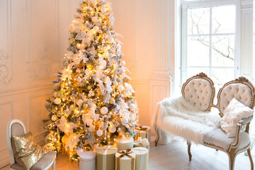 luxurious expensive light interior living room in a royal style decorated with a very beautiful Christmas tree and large windows