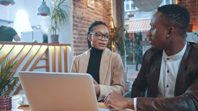Afro-american HR manager employer talking to female job candidate about career opportunity corporate plans having business conversation in cafe.