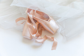 New pastel beige ballet shoes with satin ribbon and tutut skirt isolated on white background....