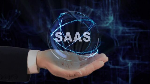 Painted hand shows concept text SaaS hologram on his hand. Drawn man in business suit with future technology screen and modern cosmic background