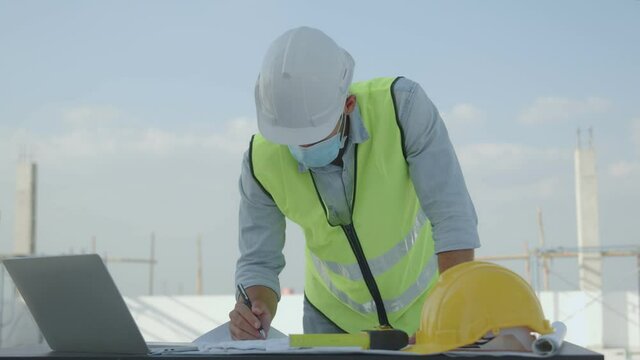 Slow motion of engineer  working on table on top of construction site, technician man check and work on laptop
