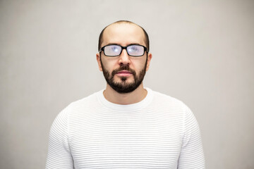 Fototapeta premium Portrait of a serious man with eyeglasses. White background.