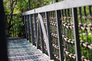 Close up view from the side of the metal canopy walkway through the treetop