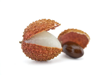 Lychee fruit opened and showing seed on white