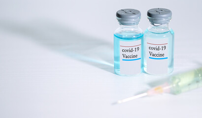 Coronavirus COVID-19 concept. blue liquid in vaccine vials and Syringe on white background and copy space for text