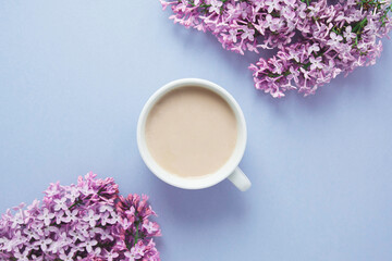 Obraz na płótnie Canvas spring wallpaper blue color, white coffee cup and lilac branch, place for text 