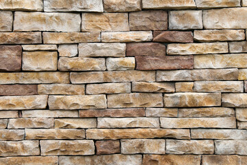 natural stack rock stone wall building facade with deep shadows in natural sunlight
