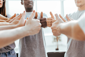 close up. group of young people showing thumbs up.