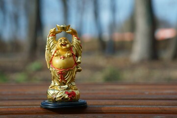 A statuette of a smiling Buddha with a Cup in his hands.