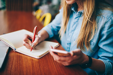 Female student making notes in notebook